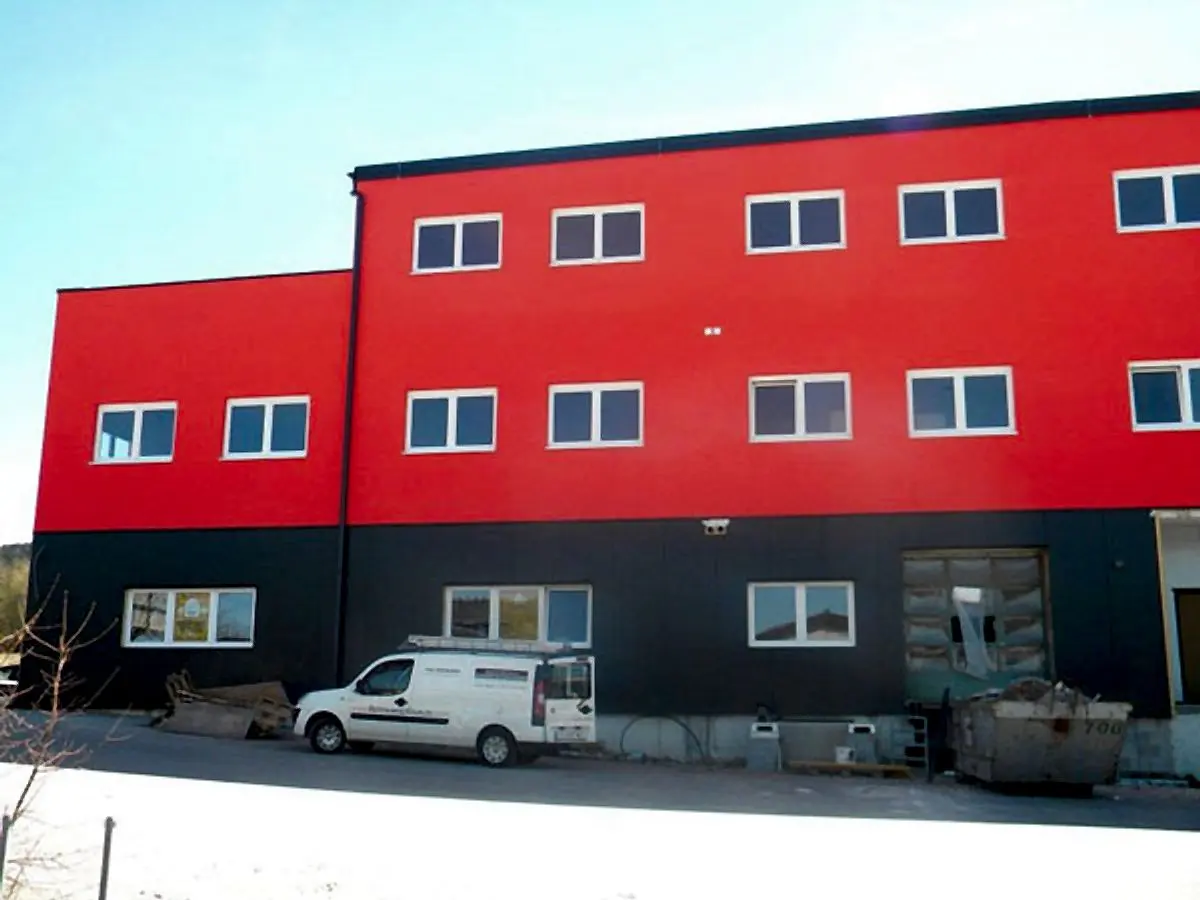 Gebäude mit roter und anthrazitfarbener Fassade