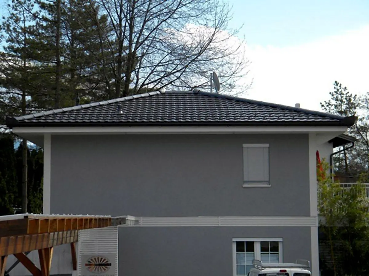 Graues Haus mit dunklem Walmdach